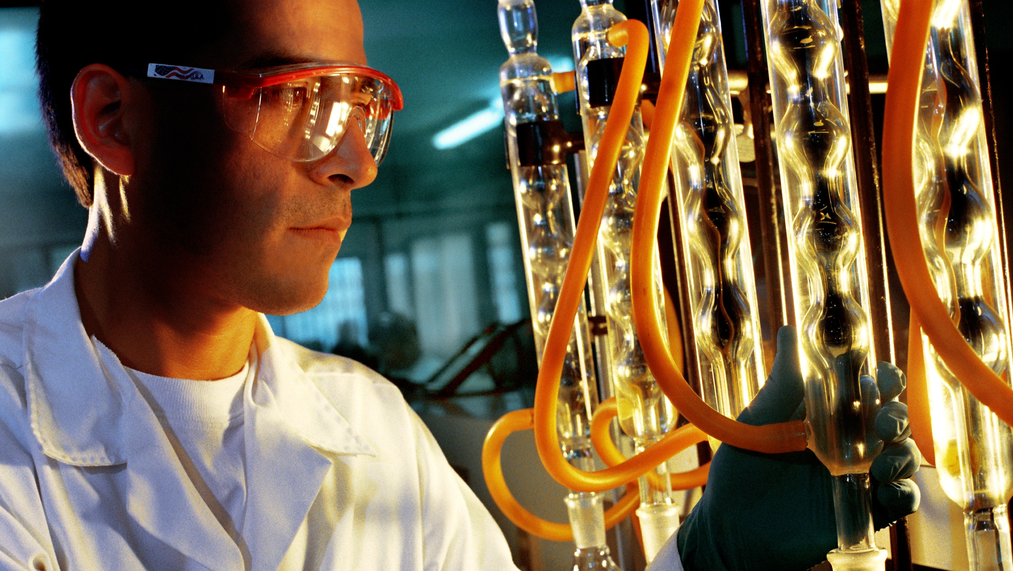Man in labcoat and safety goggles ensuring quality assurance in lab