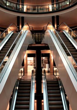 Image of two empty escalators in a mall connecting the first floor to the second floor