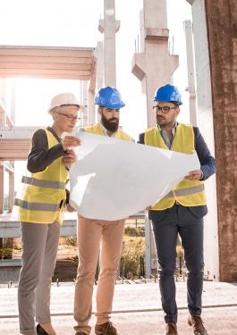 Three people reviewing plans at a client property site