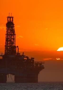 Offshore rig in front of bright orange sunset