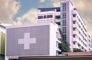 Concrete hospital building with medical cross