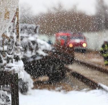 Blurred image of workers and first responders at a train track during snowfall